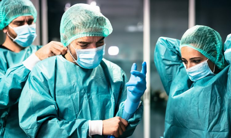 Three doctors preparing for surgery.