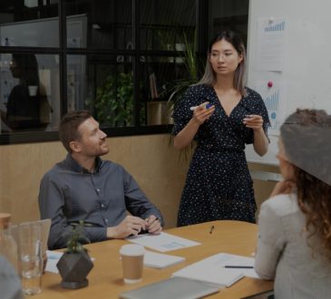 Woman giving presentation in front of colleagues in board room