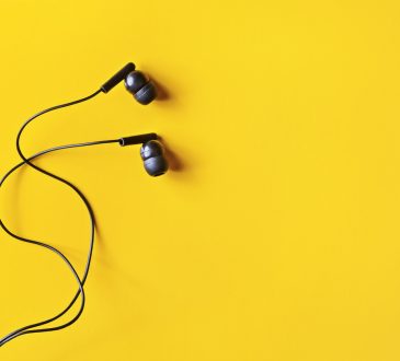 Black ear buds on yellow background