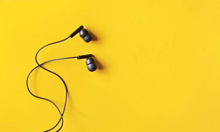 Black ear buds on yellow background