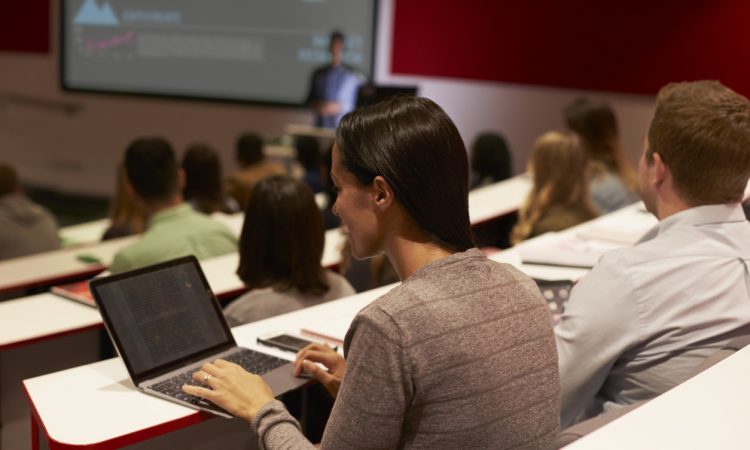 Adult student using laptop computer at a university lecture
