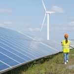 A female engineer is walking beside solar panels