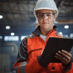 Female Industrial Specialist Walking in a Metal Manufacture Warehouse.