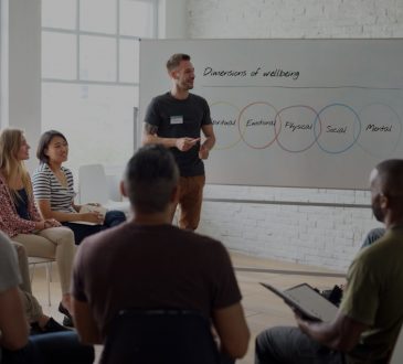Man presenting on workplace wellness at meeting