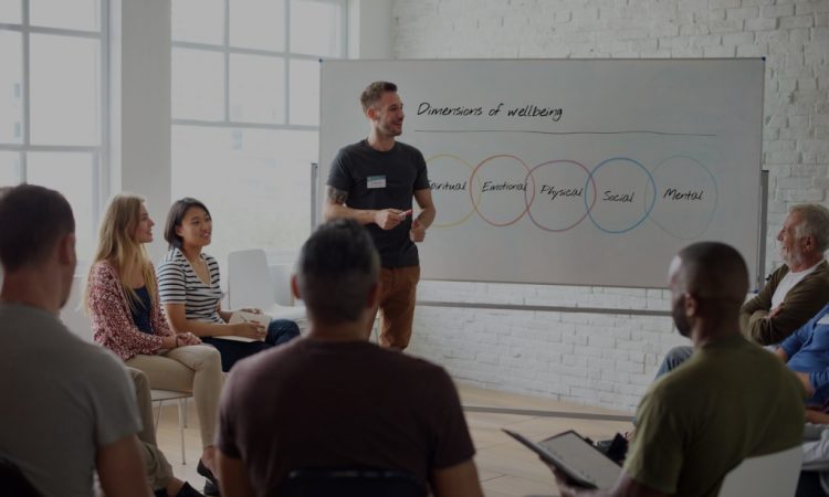 Man presenting on workplace wellness at meeting