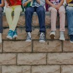 Youth sitting on brick wall