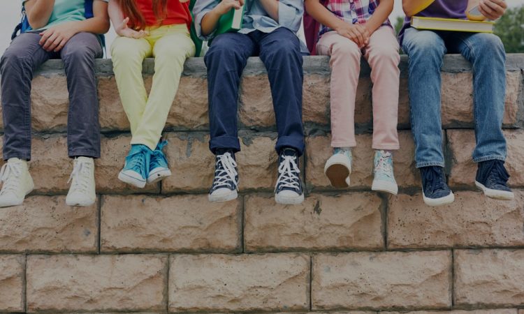 Youth sitting on brick wall