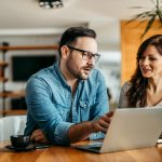 Man and woman looking at laptop at work
