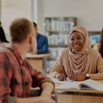 Two adult students talking in classroom.