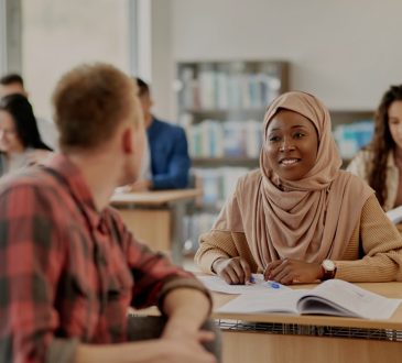 Two adult students talking in classroom.