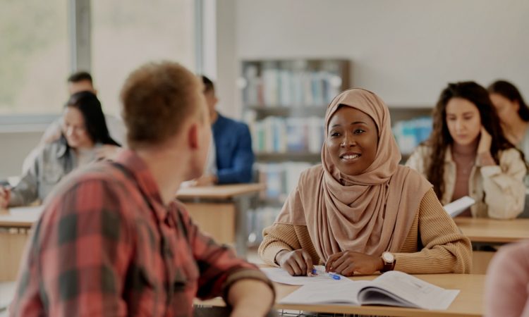 Two adult students talking in classroom.
