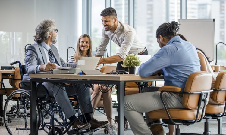 Group of colleagues sitting around table in office