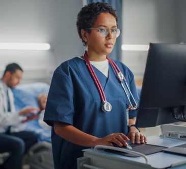 Black doctor using computer in hospital