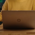 Closeup from neck down of woman using computer.