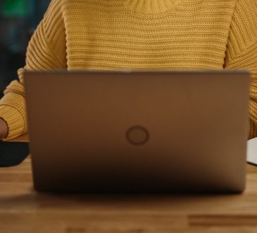 Closeup from neck down of woman using computer.