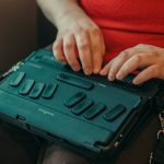Closeup of woman's hands typing on braille keyboard