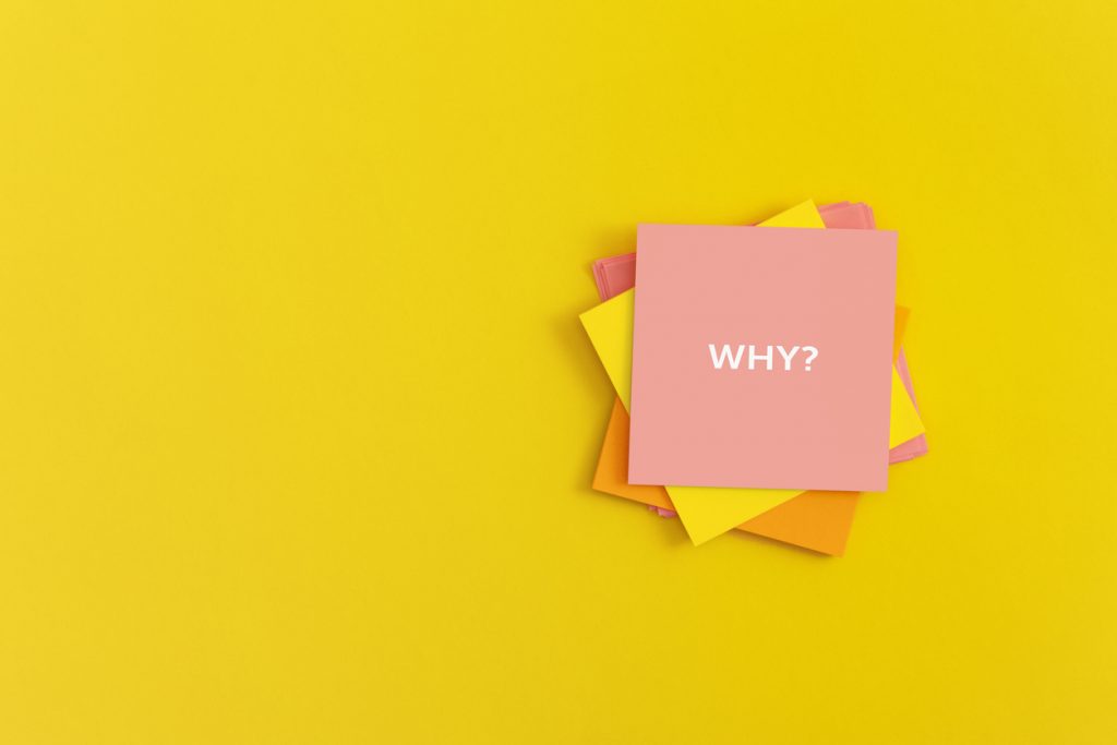 Sticky notes with word WHY on yellow background.