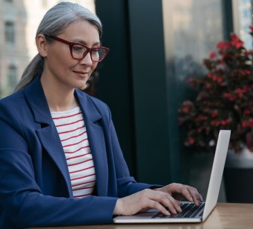 Pensive mature businesswoman using laptop