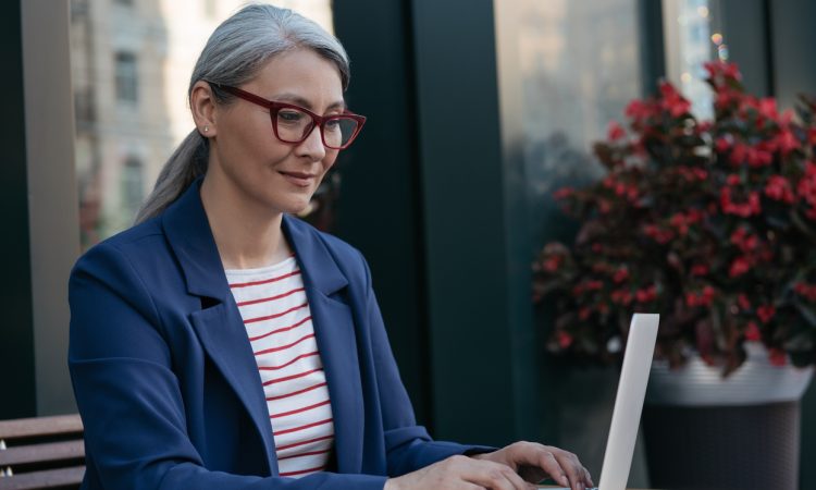 Pensive mature businesswoman using laptop