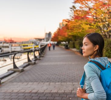 Woman walking alongside harbour in Vancouver