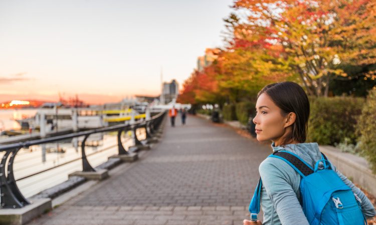 Woman walking alongside harbour in Vancouver