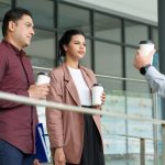 Coworkers talking during coffee break outside of building