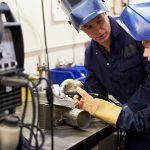 Man teaching student how to weld