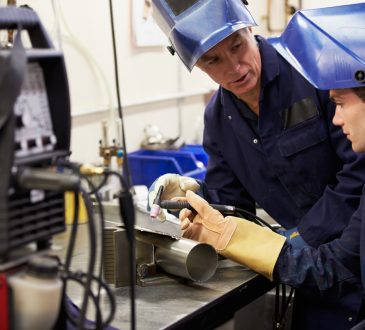 Man teaching student how to weld