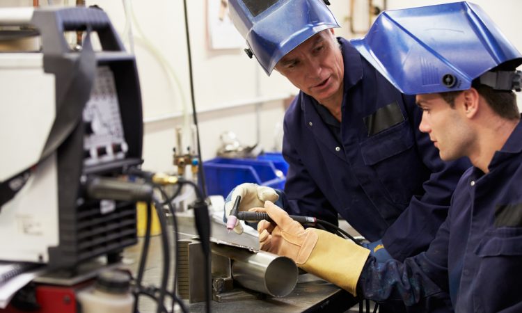 Man teaching student how to weld