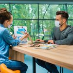 Man and woman in office looking at chart on paper together