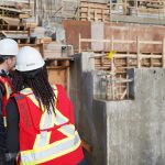 Two people looking at foundation on construction site
