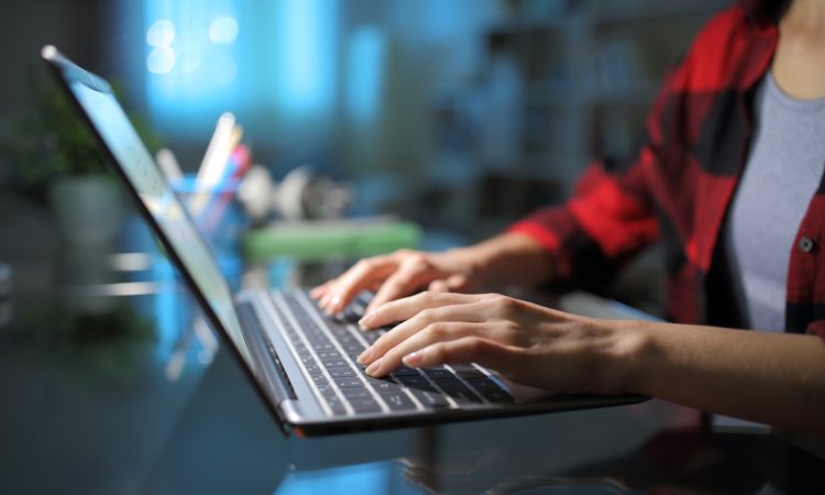 Hands typing on laptop