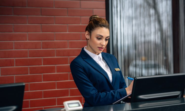 Hotel receptionist using computer
