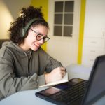Young woman smiling while working on laptop