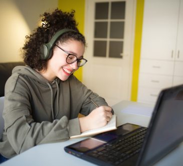 Young woman smiling while working on laptop