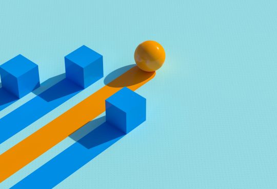 Two cubes and sphere with lines trailing behind as representation of winning business strategy