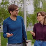 Man and woman having walking meeting outdoors.