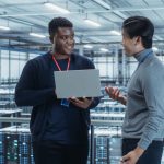 Two IT workers standing and talking in data centre