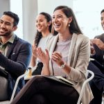 People clapping in audience at conference