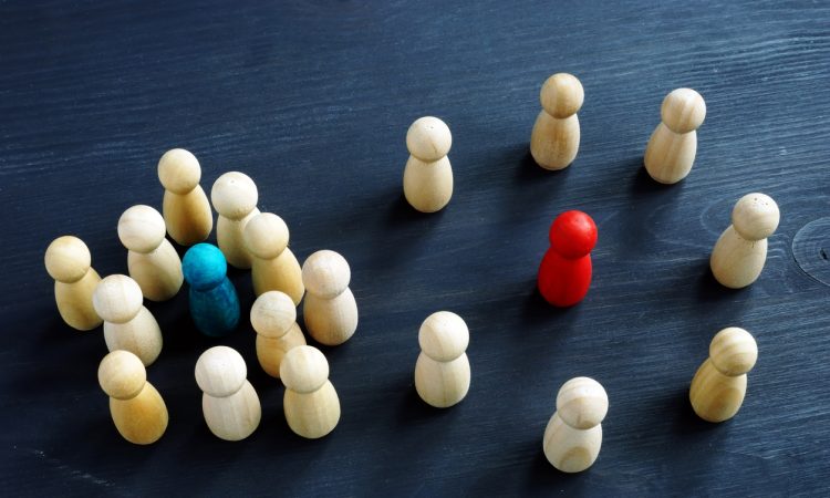 Introvert and extrovert concept. Wooden figurines on a desk.