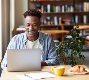 Man using laptop in cafe