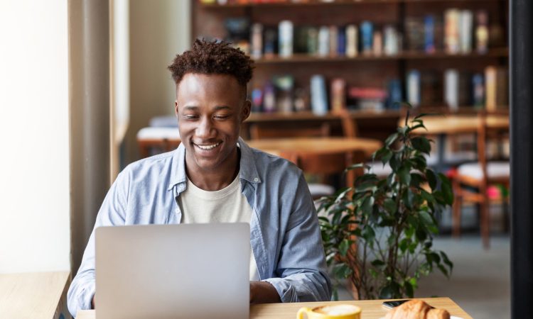 Man using laptop in cafe