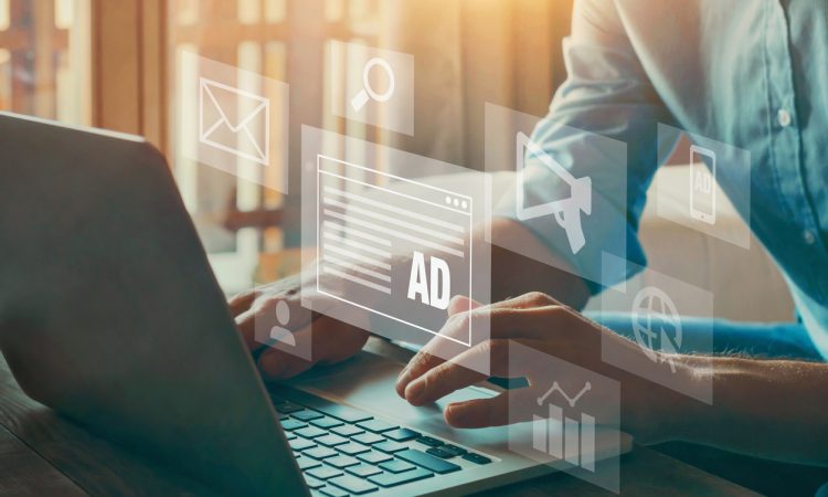 Person typing on computer overlaid with icons representing digital marketing (chart, megaphone, ad)