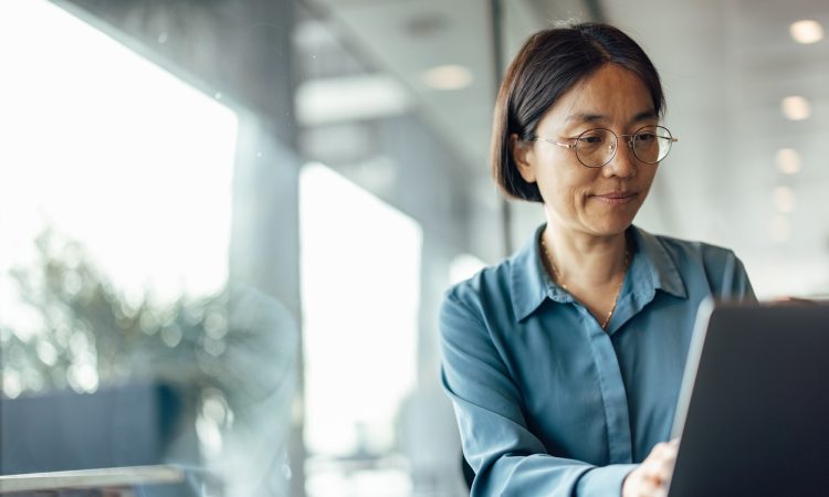 East Asian woman working on laptop in office
