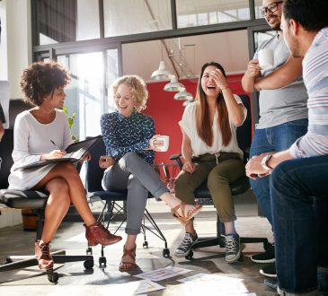 Group of coworkers laughing in office