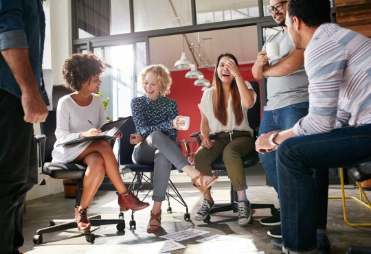 Group of coworkers laughing in office