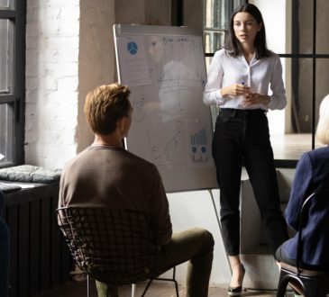 Woman giving flip chart presentation to group of people
