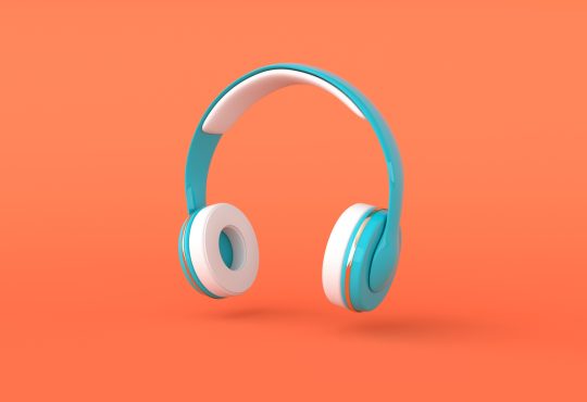 Teal over-ear headphones on orange background
