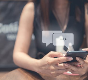 Woman texting with chat bubbles above phone