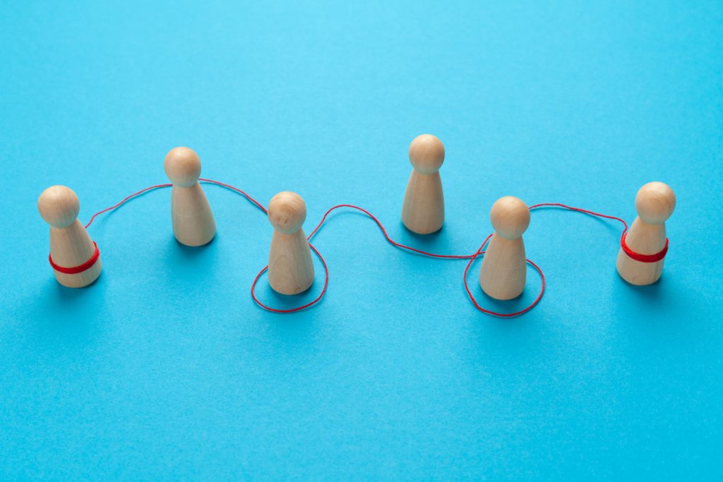 Word of mouth. The figures of people are connected with a thread.